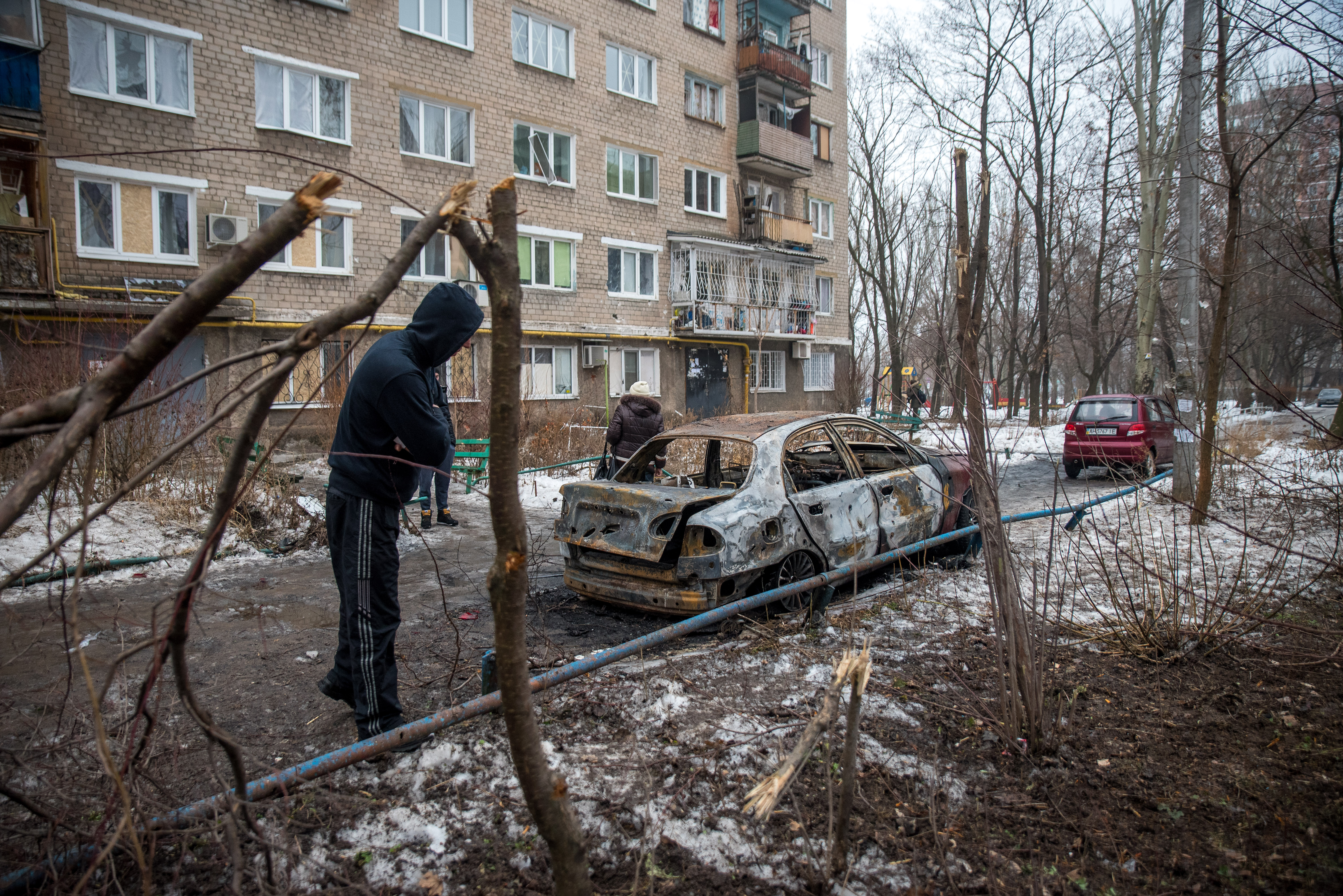 1/19: A burned out car in Donetsk city center that was hit by a mortar bomb. Note the amount of shrapnel damage to the trees and building in background. (Photo Credit: James Sprankle)