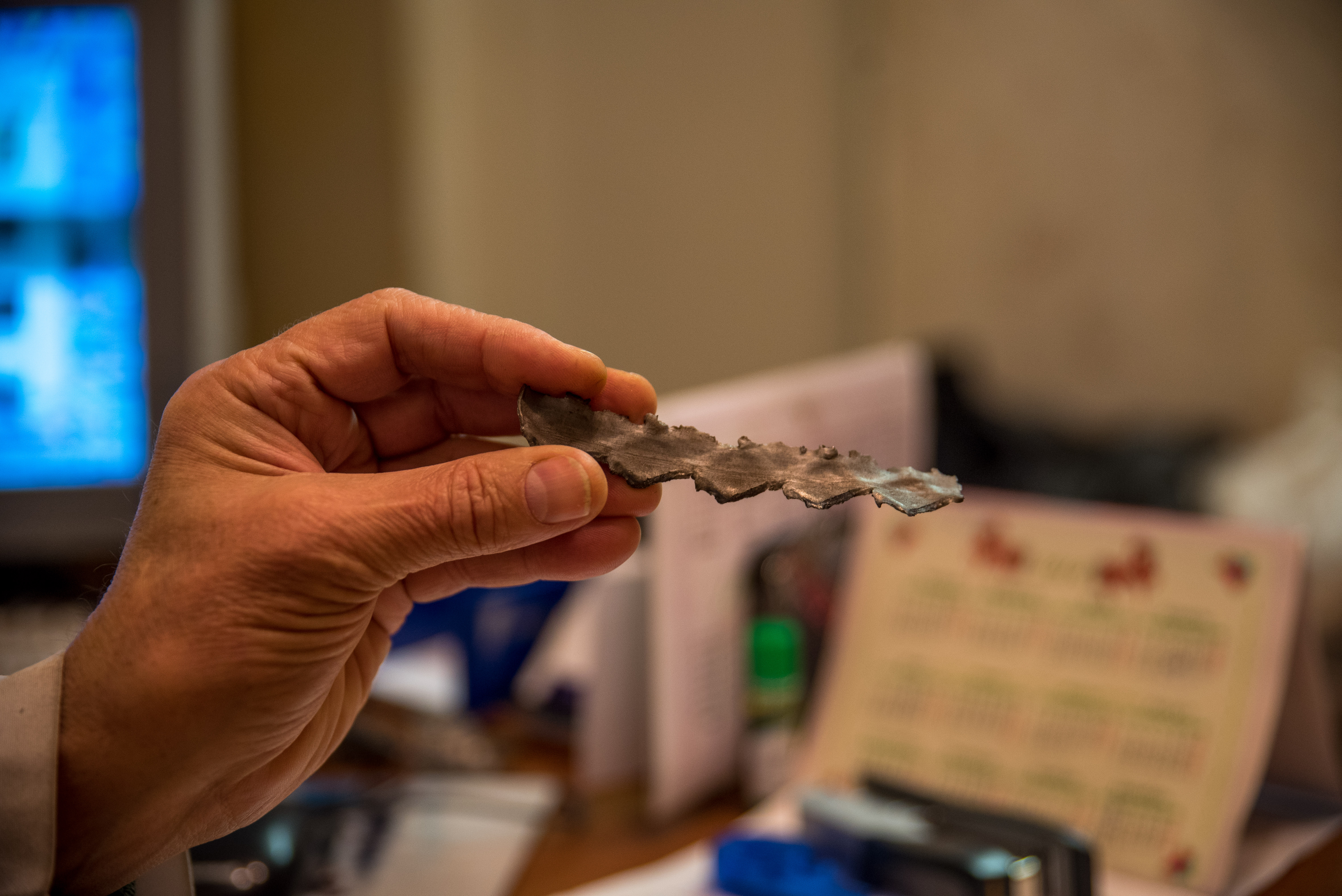 1/21: A doctor holds up a razor-sharp piece of shrapnel from a Grad rocket. Ukrainian shells hit his hospital in Donetsk three different times. (Photo Credit: James Sprankle)