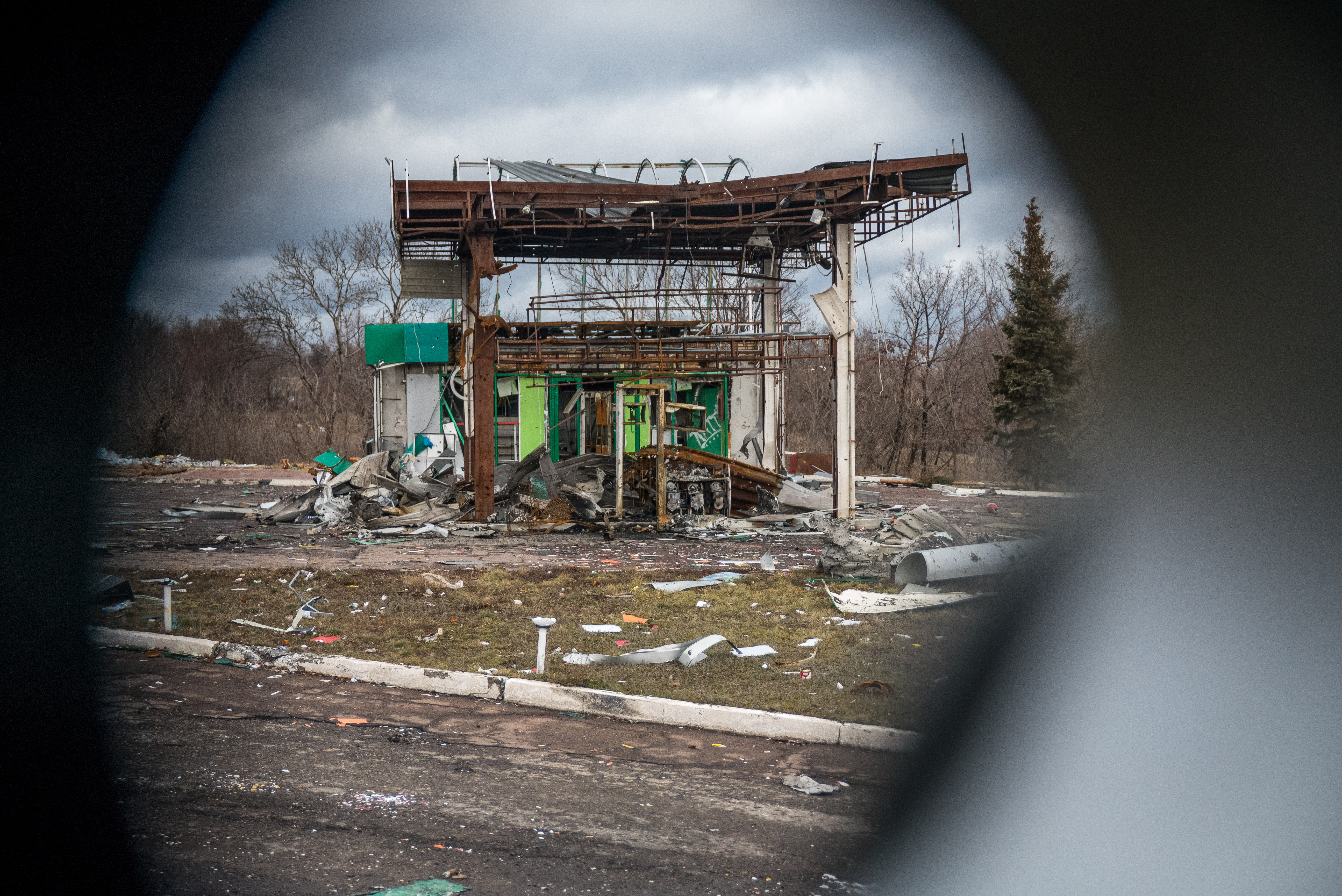 12/25: The remains of a gas station near Debaltseve as seen through the gun port of my armored personnel carrier. (Photo Credit: James Sprankle)