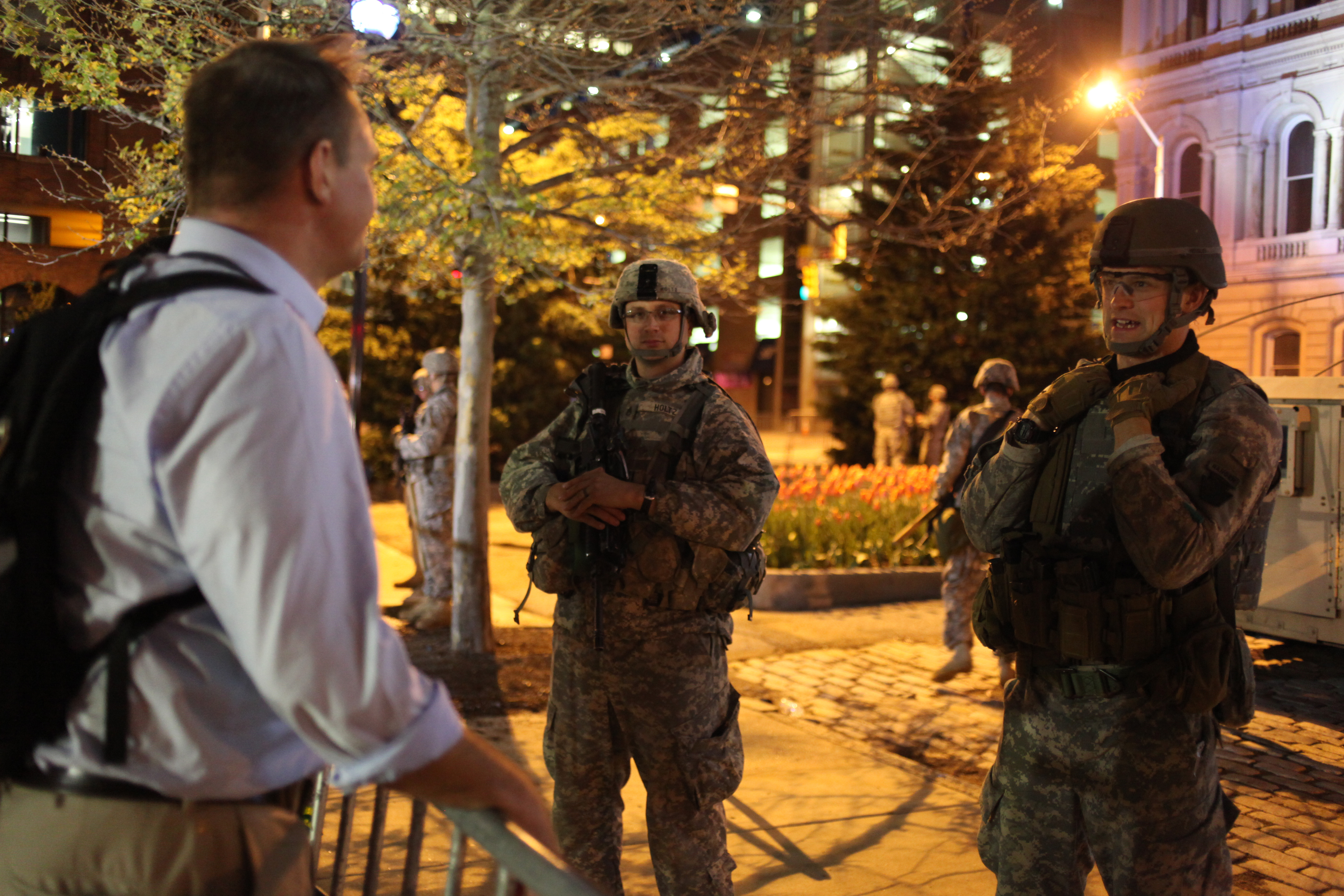 Medill National Security Specialization student Matthew Schehl speaks with Maryland Army National Guard soldiers in front of Baltimore City Hall on April 30, 2015. (Jennifer-Leigh Oprihory/MEDILL NSJI)
