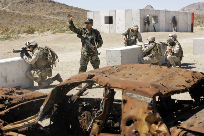 An Afghan soldier, second from left, and U.S. Marines respond to an explosion inside a mock Afghan village during a training exercise on Sept. 23, 2008, at the Marine Corps Air Ground Combat Center in Twentynine Palms, Calif. The U.S. Marine Corps recently licensed another 300 square miles at Twentynine Palms from the Bureau of Land Management.