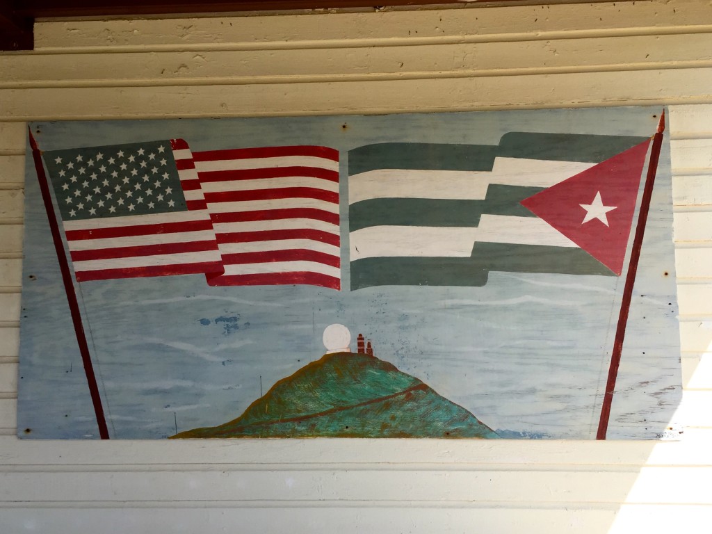 A painting shows U.S. and Cuban flags flying outside of the Guantanamo Bay Lighthouse Museum.