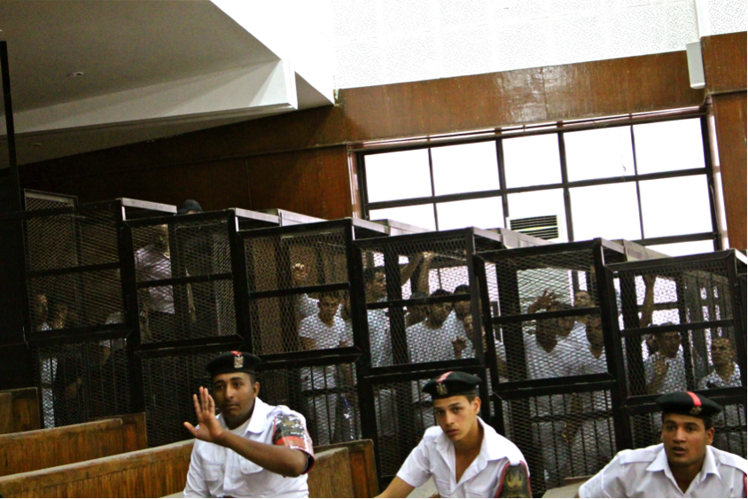 Detainees, including a journalist, are held in a Cairo courtoom. (Amina Ismail)