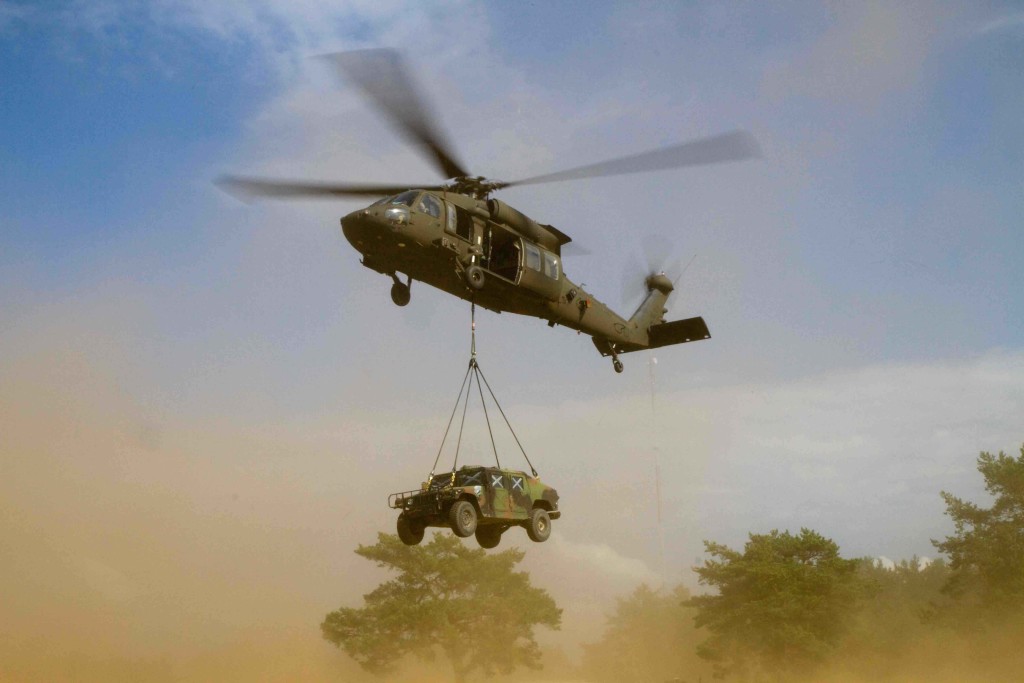 A UH-60M Black Hawk helicopter being operated by B Company, 43rd Assault Helicopter Battalion, 3rd Cavalry Regiment, 3rd Infantry Division, lifts off after having a High Mobility Multipurpose Wheeled Vehicles (HMMWV) sling loaded to it by Soldiers on the ground assigned to Dog Company, 1st Battalion, 503rd Infantry Regiment, 173rd Infantry Brigade Combat Team (Airborne), 4th Infantry Division and Lithuanian Land Forces Soldiers assigned to the Grand Duchess Birutė Uhlan Battalion (BUB), during exercise Uhlan Fury being held at the Gen. Silvestras Zlikaliskas Training Area, Pabrade, Lithuania, Aug. 10, 2015. The U.S. units are in Europe as part of Atlantic Resolve, a demonstration of continued U.S. commitment to the collective security of NATO and to enduring peace and stability in the region. U.S. Army Europe is leading Atlantic Resolve enhanced land force multinational training and security cooperation activities taking place across Estonia, Latvia, Lithuania, Romania, and Bulgaria to ensure multinational interoperability, strengthen relationships among allied militaries, contribute to regional stability and demonstrate U.S. commitment to NATO. (U.S. Army Photo by Sgt. James Avery, 16th Mobile Public Affairs Detachment)