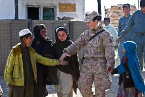 U.S. Navy Petty Officer 2nd Class Kimberley Ryan holds hands with Afghan children near Forward Operating Base Jackson in the Sangin district of Afghanistan’s Helmand province, Jan. 20, 2012. Ryan is the team leader of the Female Engagement Team, which conducts classes and provides educational opportunities for civilians. (Cpl. Ed Galo/U.S. Marine Corps)